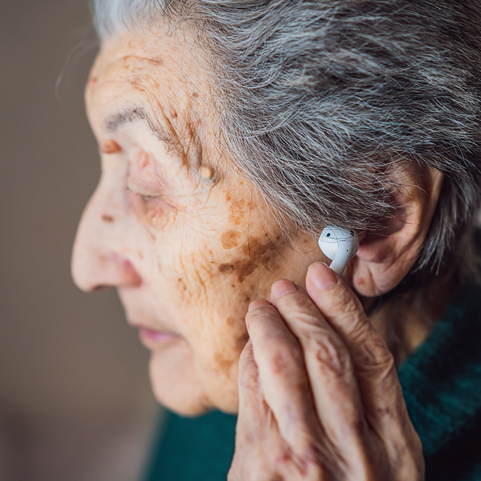 Elder woman with ear phone