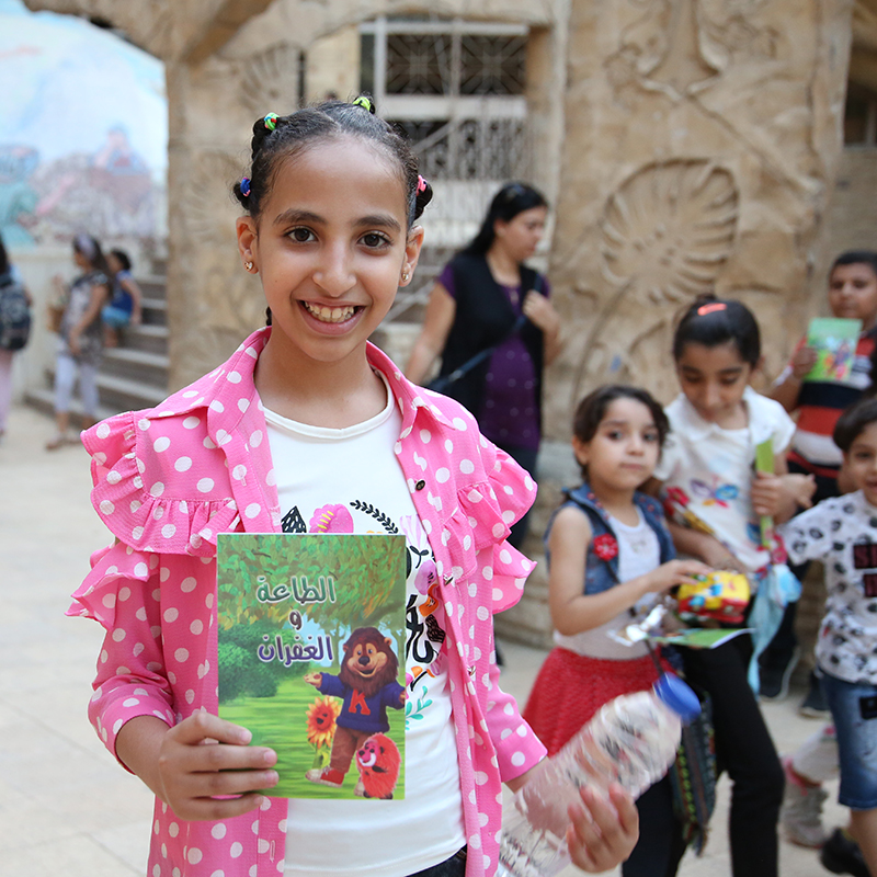 Smiling child with illustrated Bible